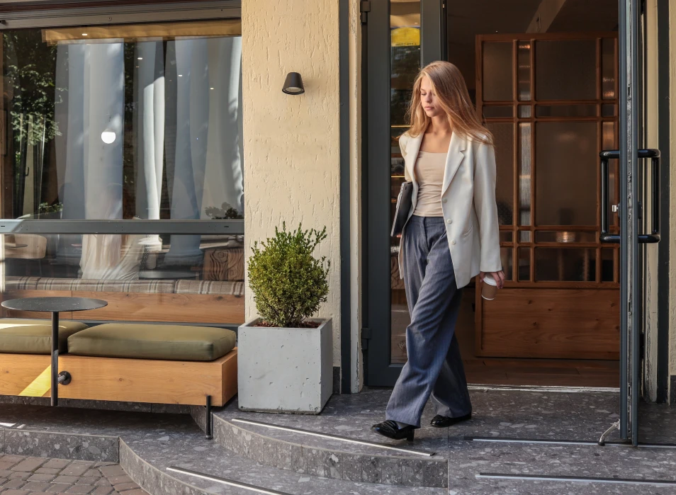 Bequem und schick zugleich! Der Casual Look zeigt sich von unterschiedlichen Seiten. Frau trägt modernen Zweiteiler, weit geschnittene Stoffhose in Anthrazit, Top in Creme und hellgrauen Oversized Blazer