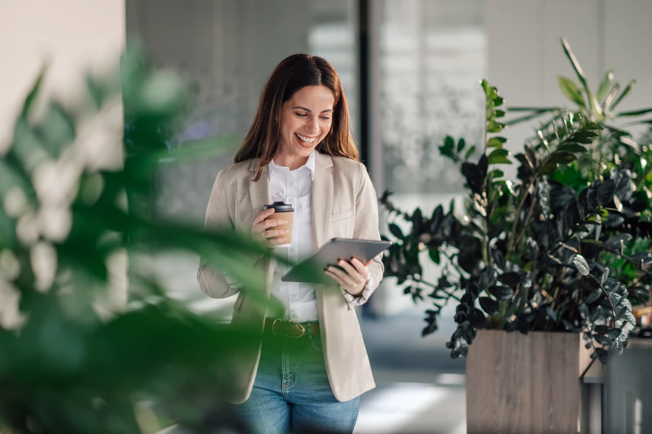 Eine Bluse in Kombination mit Jeans ist ein stilvoller Smart Casual Look fürs Büro. Smart Casual Outfit Damen für das Büro, Frau trägt dunkle Jeans, mit weißer Bluse und hellem Blazer