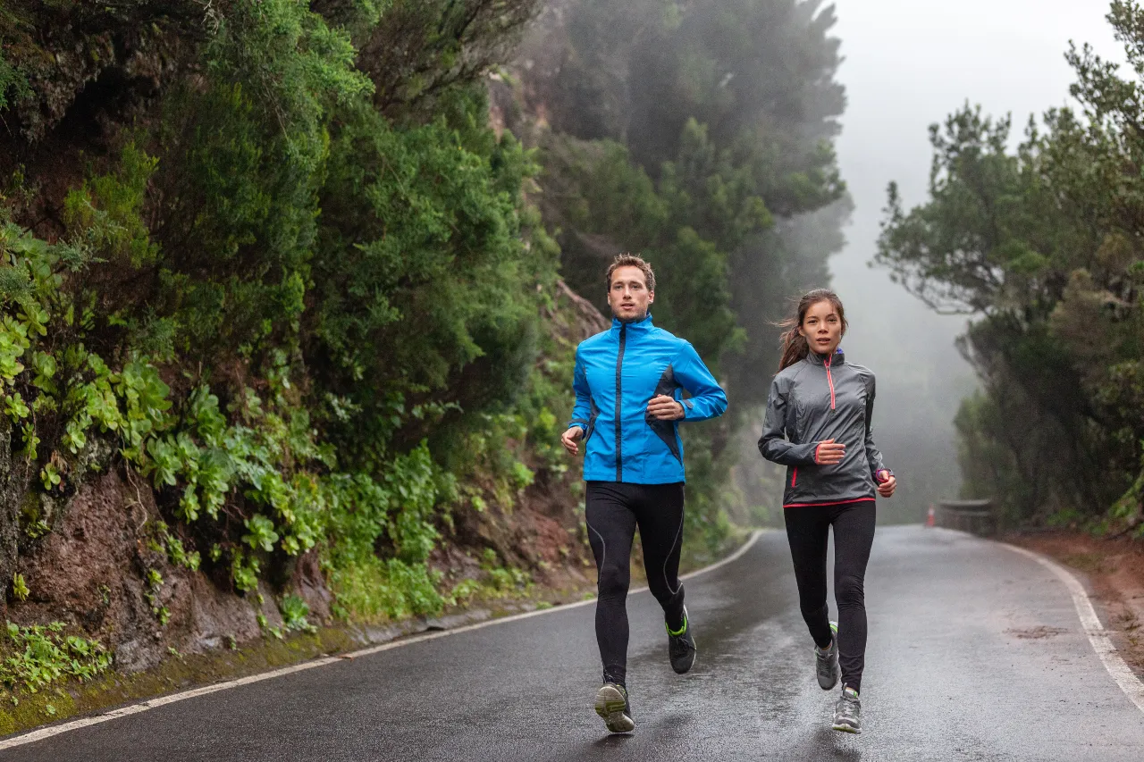 Frau und Mann joggen in Laufbekleidung für die Übergangszeit