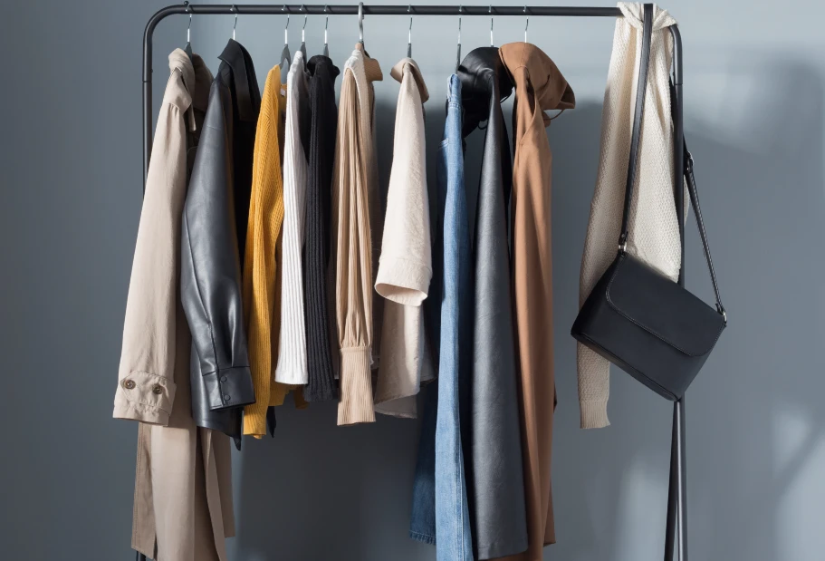 Ein paar Basics und schon haben Sie einen minimalistischen Look Kleiderstange mit Kleidung in einfarbigen Tönen