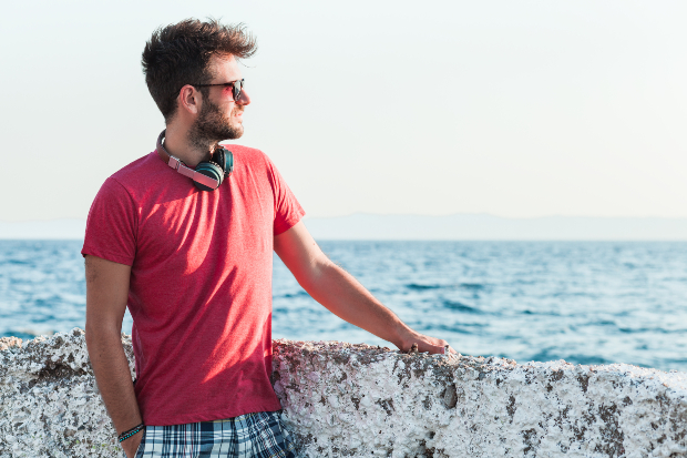 Mann mit rotem T-Shirt am Meer