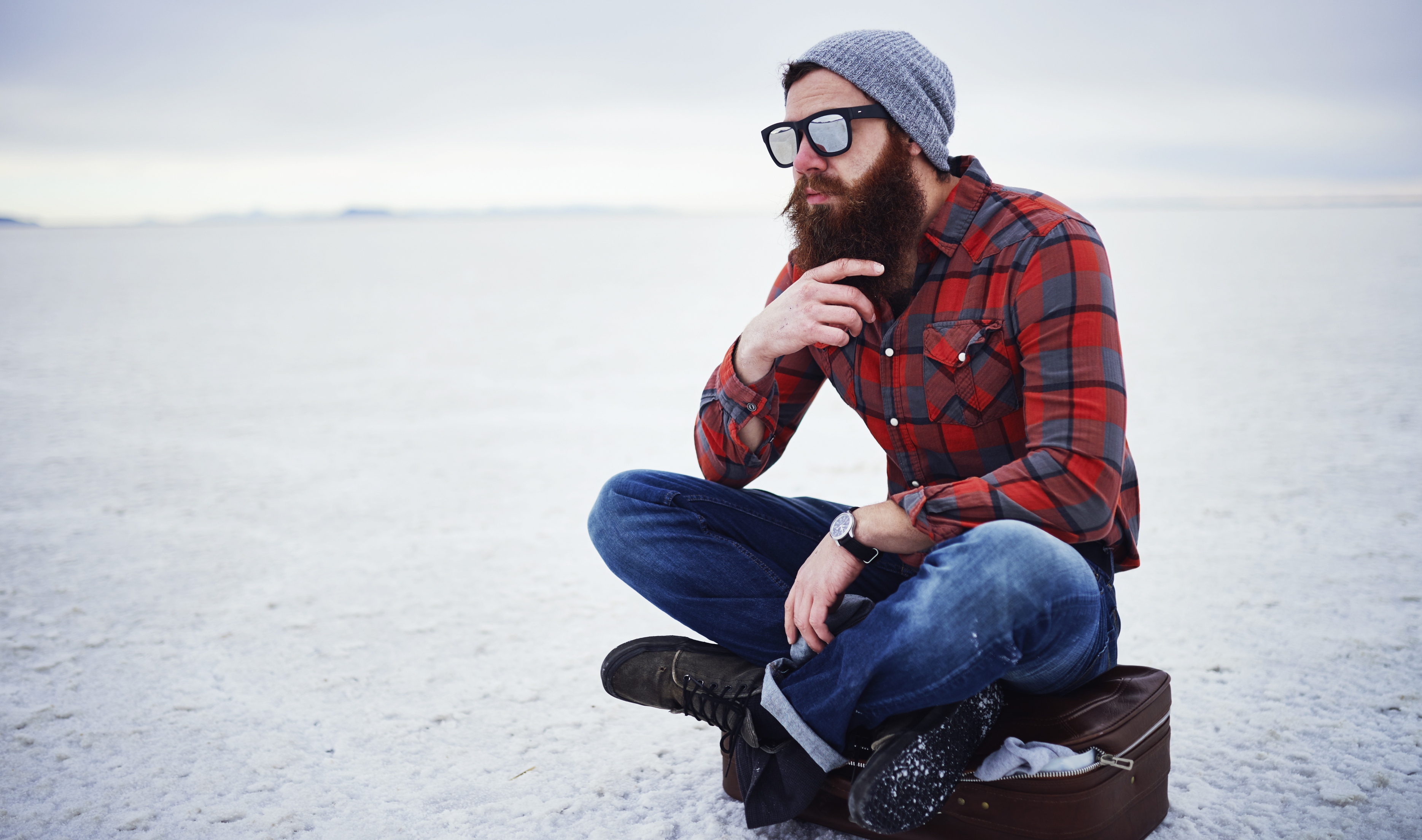 Junger Mann in Holzfällerhemd und Jeans
