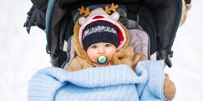 Baby im Kinderwagen in Babykleidung im WInter