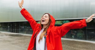 Junge Frau lächelnd im Regen - Regenfeste Kleidung modisch kombiniert