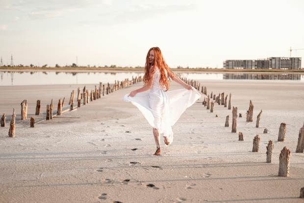 Dame im weißen Kleid am Strand