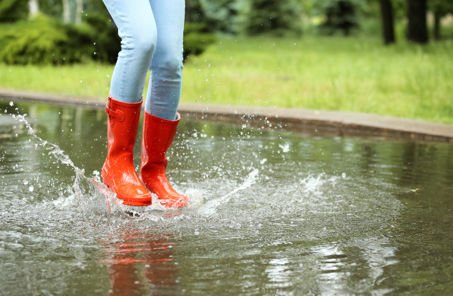 Frau mit Gummistiefeln - Teil der idealen Schlechtwetterkleidung