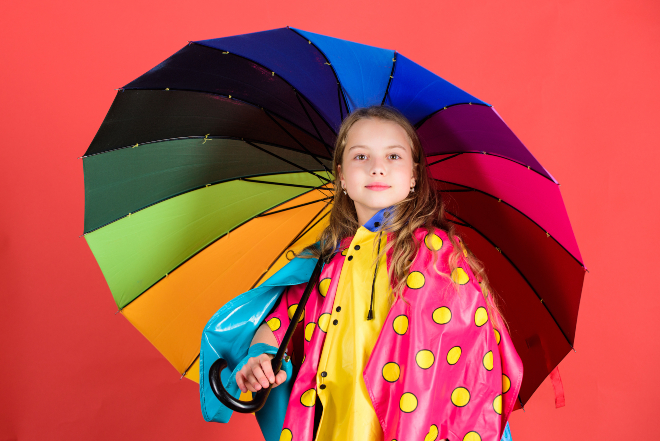 Mädchen mit buntem Regenschirm und Cape - Ideale Schlechtwetterkleidung