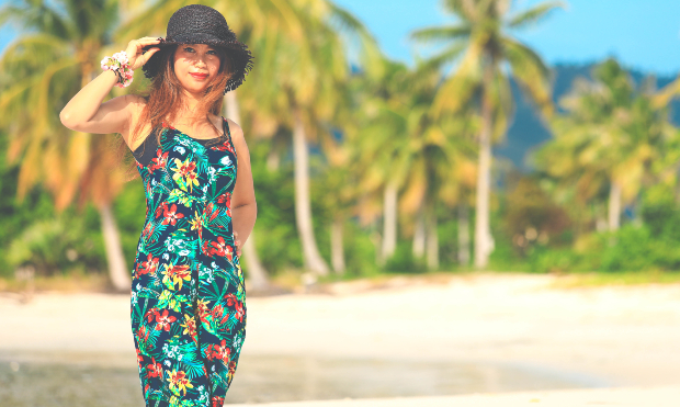 Junge Frau am Strand mit blumigem Outfit