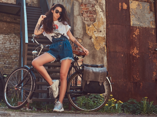 Frau mit Denim Shorts am Fahrrad