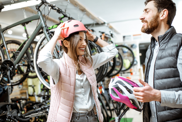 Junger Mann und junge Frau im Radladen, tragen beide eine Sportweste