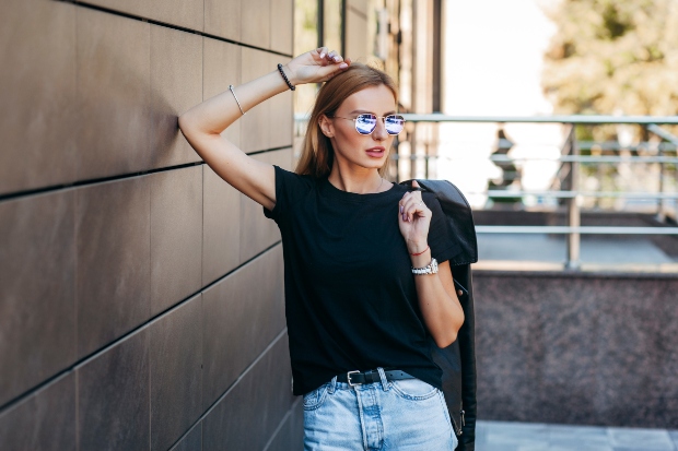Junge Frau in T-Shirt und Jeans mit Sonnenbrille - Einfache Mode