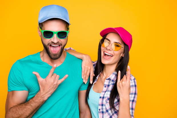 Mann und Frau in sommerlichem Outfit mit coolen Sommerkappen und Sonnenbrillen