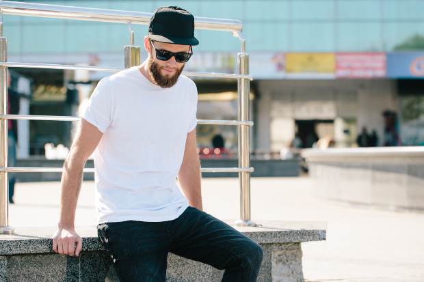 Junger Mann in Jeans, T-Shirt und Baseball-Cap