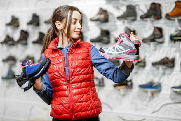 Junge Frau in roter Weste mit Sportschuhen in der Hand - Schöne Damenwesten