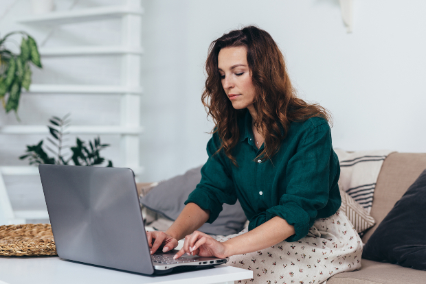 Junge Frau mit Hemd und Sommerrock am Laptop - Leichtes Outfit für zuhause