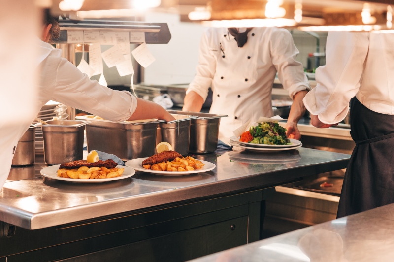 Essensbestellungen auf dem Kuechentisch Gastronomiebekleidung