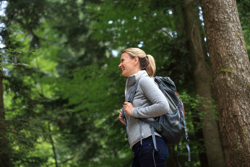 Glueckliche Frau beim Wandern im Wald