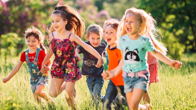 Coole Kleidung für coole Kids Kinderhorde tobt durch die Wiese