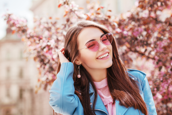 Eine junge Frau trägt ein rosafarbenes Kleid in Kombination mit einer blauen Lederjacke Pinke Kleidung kombinieren