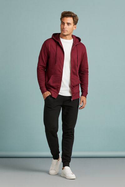 Sportlich-bequemer Layering-Look mit Hoodie und Jogginghose. Mann trägt ein sportliches Layering-Outfit mit weinrotem Hoodie, weißem Langarmshirt, schwarzen Jogginghosen und weißen Sneakers – moderner Athleisure-Stil.