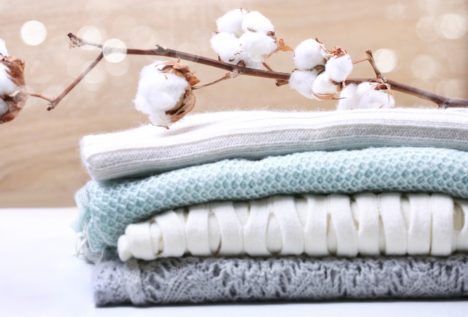 Baumwollblüten liegen auf Baumwollkleidung - Loungehosen gibt es auch aus Baumwolle