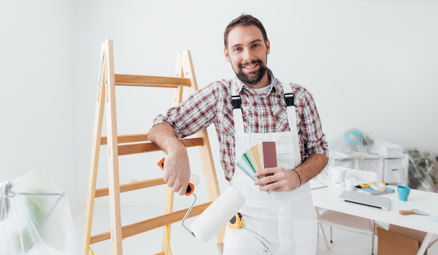 Maler in weißer Latzhose bei der Arbeit