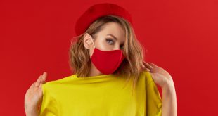 Junge modische Frau mit rotem Mund-Nasen-Schutz