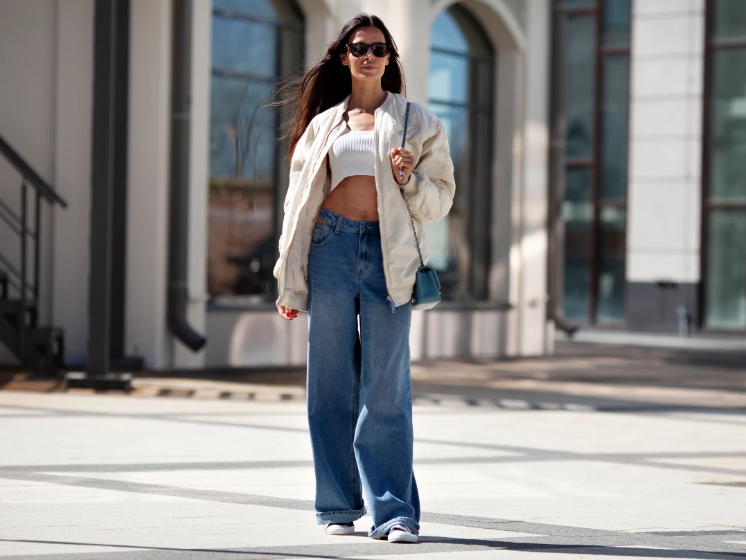 berlin-style Frau trägt weiter Jeans mit Bomberjacke und cropped Top