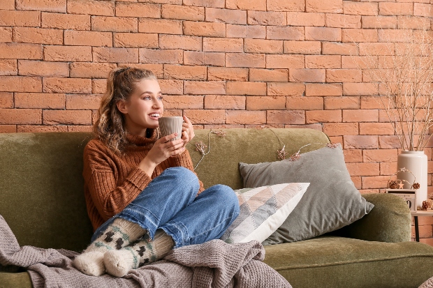 Frau in gemütlicher Kleidung auf dem Sofa 