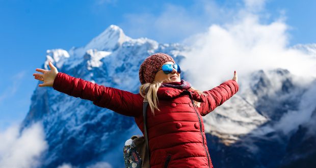 Frau in roter Jacke in den Alpen - Winterfarben Trends