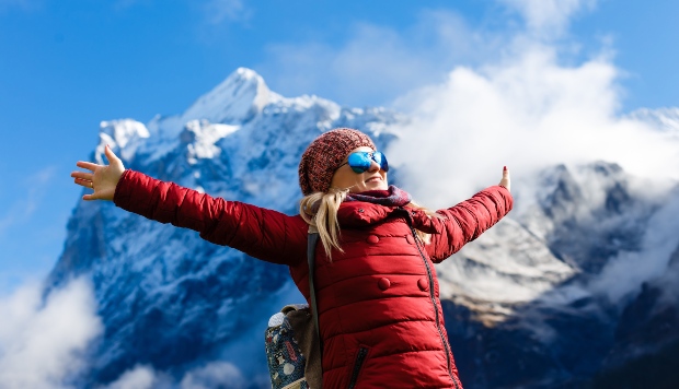 Frau in roter Jacke in den Alpen - Winterfarben Trends