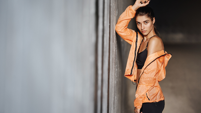 Frau in orangefarbener Jacke im Sporty Style