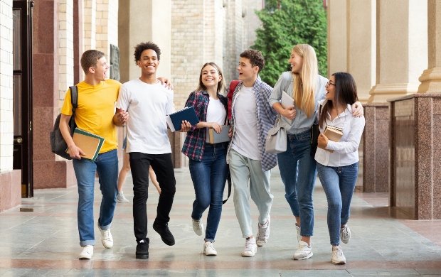 Studentengruppe am Campus - sie tragen Laptop-Rucksäcke 