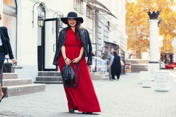 Junge, kurvige Frau mit rotem Kleid und schwarzer Lederweste - Kleidung in großen Größen