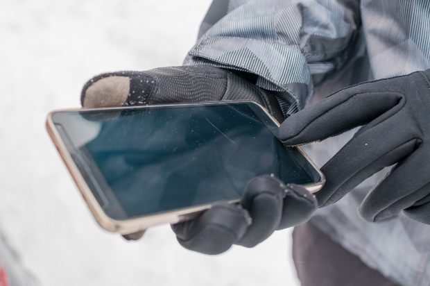 Mann benutzt Touchscreen-Handschuhe für sein Handy
