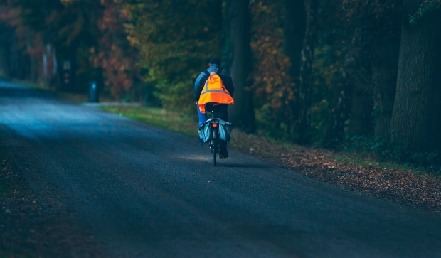 Mann auf Fahrrad bei Dunkelheit mit Sicherheitskleidung