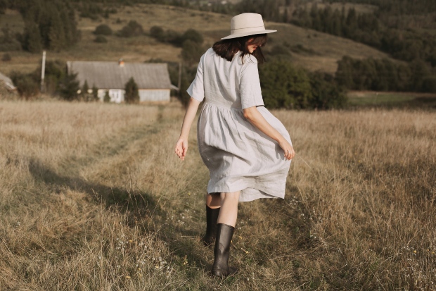 Junge Frau in einem Leinenkleid in einem Feld - Leichte Sommerstoffe