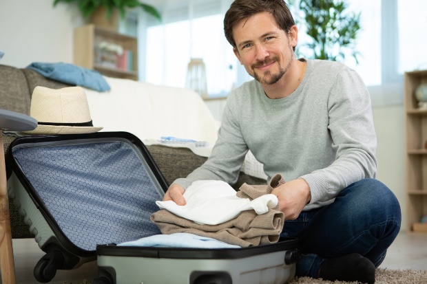 Wer vorplant, hat später keinen Stress und alle Sachen dabei Junger Mann packt in Ruhe seinen Koffer