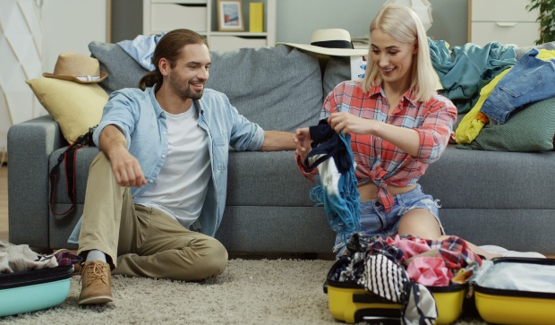 Als Paar sollte man sich logischerweise absprechen - das kann Platz sparen Junges Paar beim Koffer packen