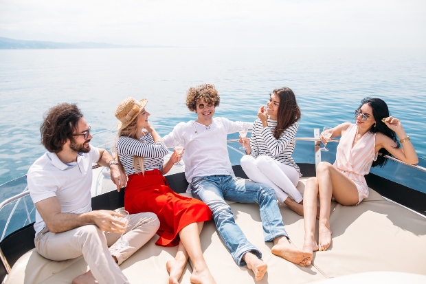 Junge Leute auf einer Yacht in Sommerkleidung