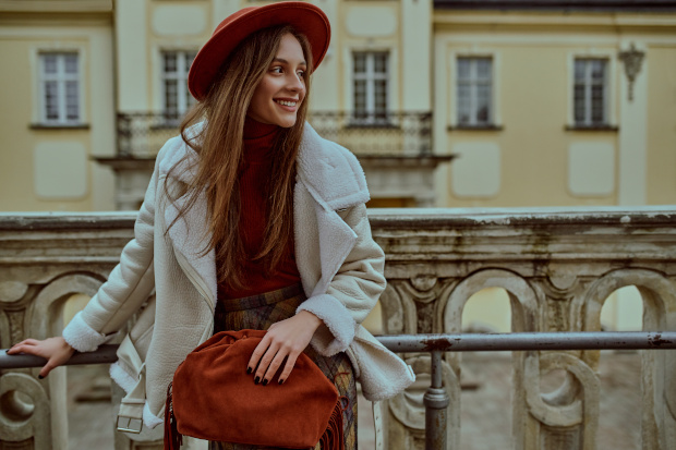 Frau im Spießer Look mit Karorock, Mantel und Hut 