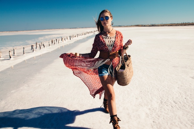 Junge Frau läuft am Strand im Boho-Style