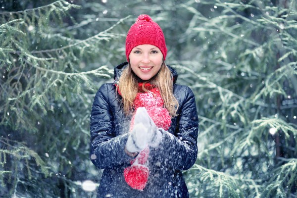 Eine junge Frau in einer blauen Winterjacke posiert in einer winterlichen Landschaft Jacken-Material