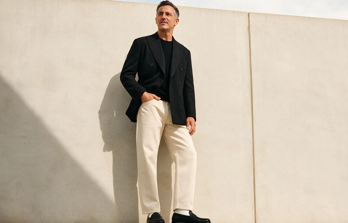 Classy und doch modern! Schwarzer Doppelreiher zur beigen Denim. Schwarzer Doppelreiher für Herren mit einer hellen Jeanshose kombiniert