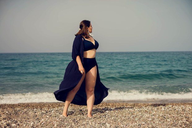 Junge Frau mit schwarzem Bikini und leichtem schwarzen Badeumhang - Trendige Badebekleidung