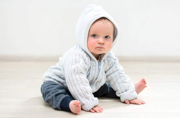 Baby sitzt mit Händen am Boden - Erstausstattung fürs Baby 