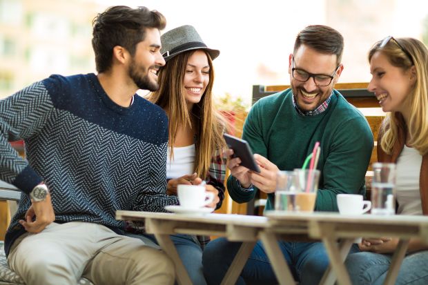 gruppe-junger-leute-am-tisch - legere Kleidung