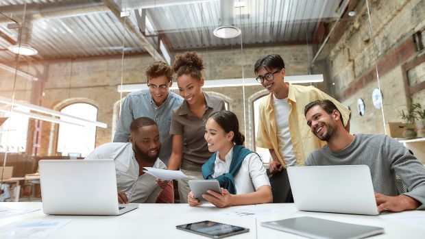 Gruppe Junger Leute im Büro mit passenden Büro-Outfits