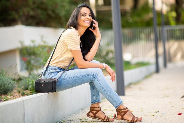 Junge Frau, elegant in Jeans und T-Shirt telefoniert mit Handy - Mit legerer Kleidung stylen