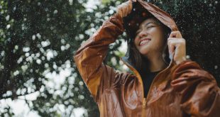 Junge frau glueclick bei regen - Regenmode